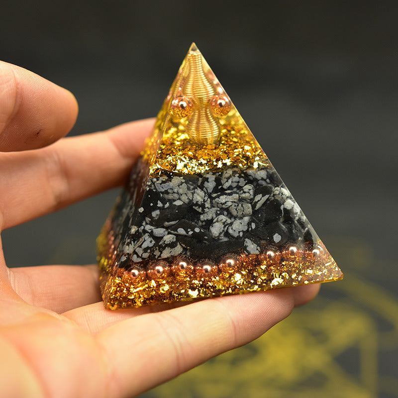 Handheld Reiki orgonite pyramid with golden glitter and textured layers for energy healing