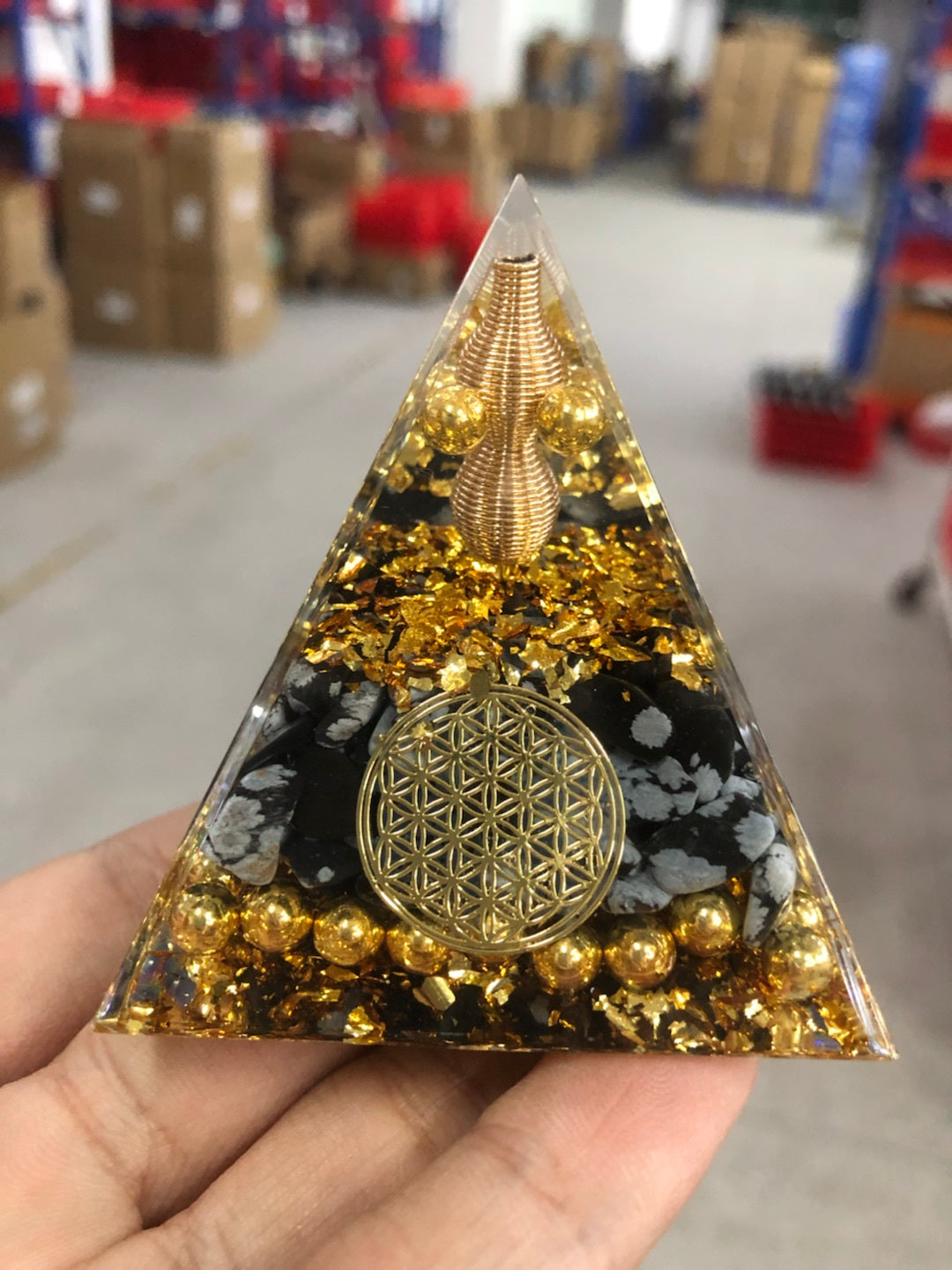 Reiki orgonite pyramid with golden flakes and black stones for energy healing and decoration