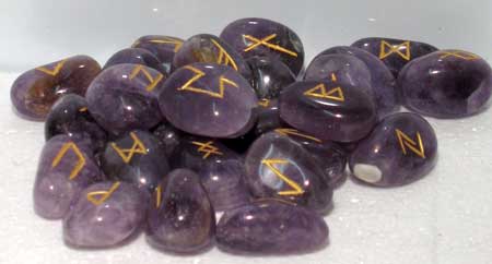 Amethyst rune set featuring engraved symbols on polished purple stones for spiritual and divination use