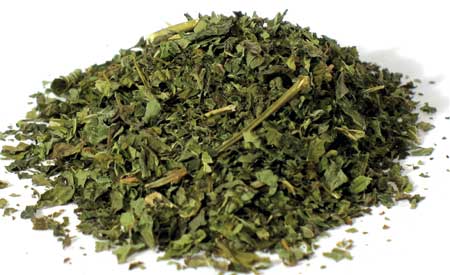 Dried cut lemon balm for tea with vibrant green leaves in a piled formation