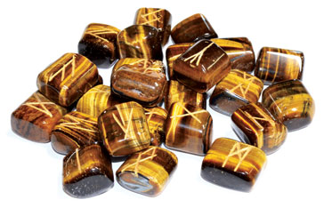 Tiger eye rune set with intricately carved runes on polished stones for divination and spiritual practices